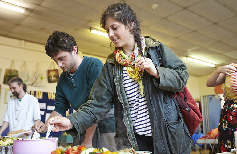 Members of the public tuck into food preparted from waste food at a Food Works pop-up cafe